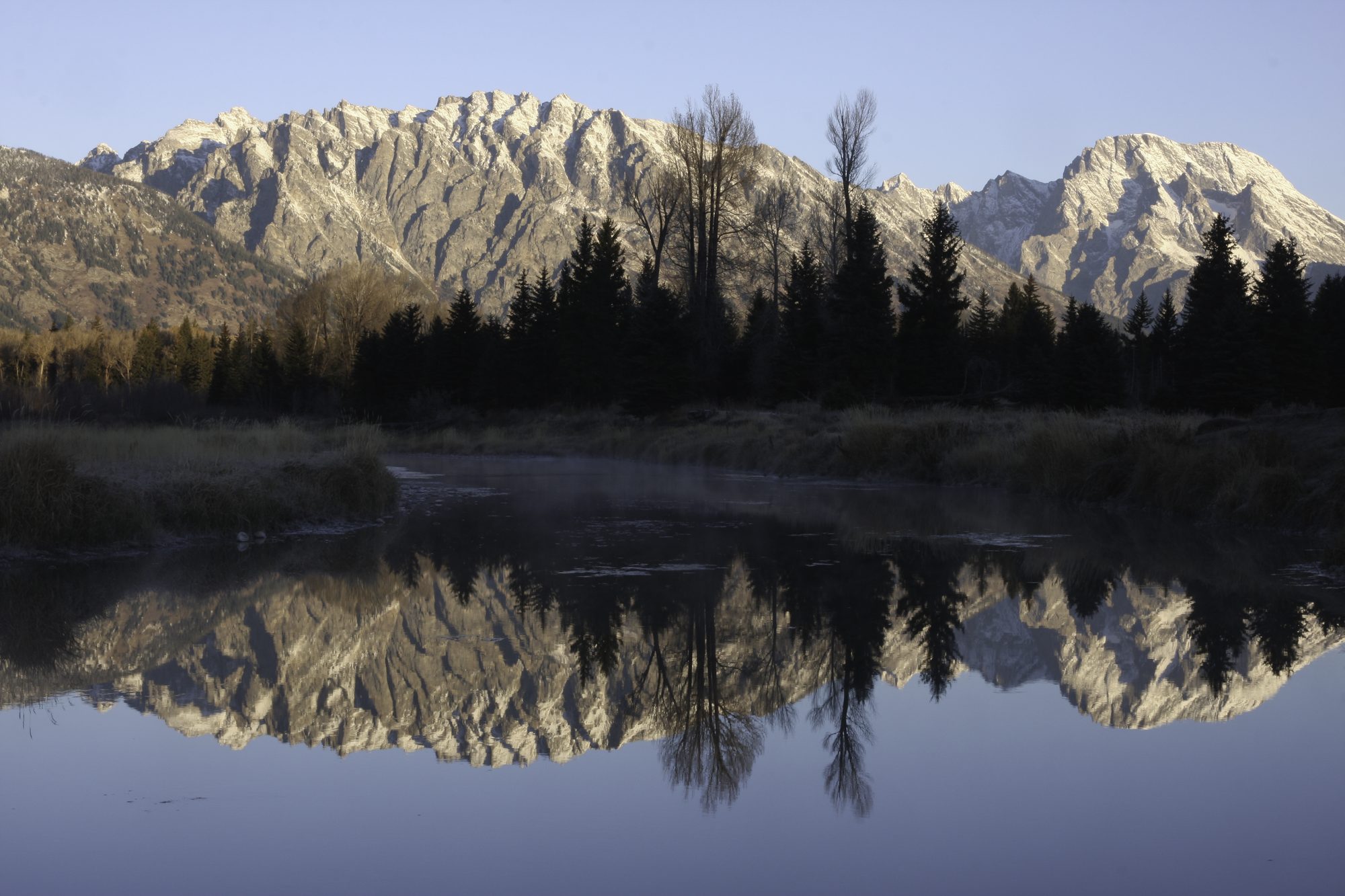 Mountains reflected in a still Montana lake at first light